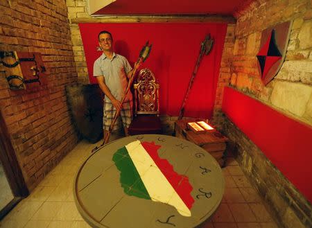 Istvan Karacsony, a manager at TRAP, holds up a battle axe in the medieval escape room, in Budapest August 1, 2014. REUTERS/Laszlo Balogh