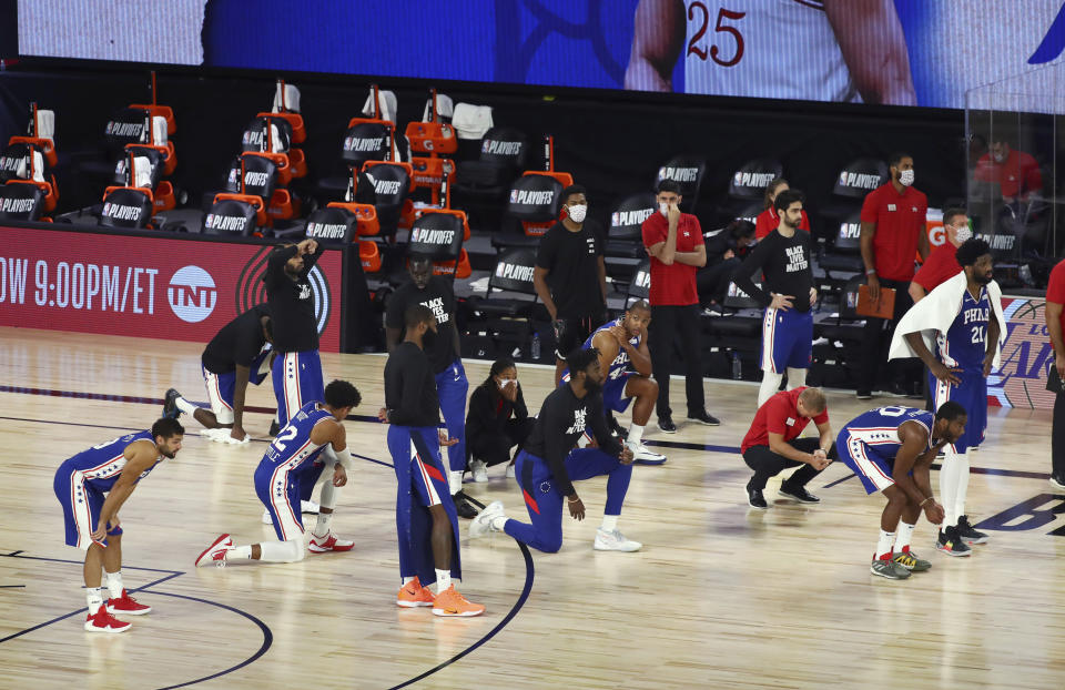 Philadelphia 76ers players react as forward Tobias Harris (not shown) is attended to after hitting his head against the Boston Celtics during the third quarter of Game 4 of an NBA basketball first-round playoff series, Sunday, Aug. 23, 2020, in Lake Buena Vista, Fla. (Kim Klement/Pool Photo via AP)