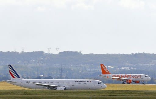 An Air France aircraft prepares for takeoff at Roissy near Paris in October 5, 2012 as an EasyJet plane lands. Air-France-KLM has suffered from a fall of competitiveness in recent years, under the pressure of low-cost operators and the rise of airlines in the Middle East and in Asia