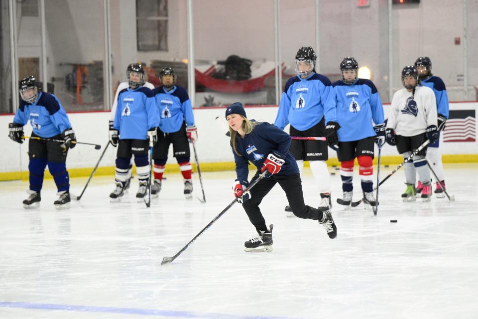 US hockey player Haley Skarupa, front, demonstrates a drill during a hockey clinic presented by the Washington Capitals and the PWHPA.