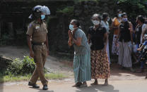 A family member of an inmate pleads to a policeman as she seeks information on the condition of her relative outside the Mahara prison complex following an overnight unrest in Mahara, outskirts of Colombo, Sri Lanka, Monday, Nov. 30, 2020. Sri Lankan officials say six inmates were killed and 35 others were injured when guards opened fire to control a riot at a prison on the outskirts of the capital. Two guards were critically injured. Pandemic-related unrest has been growing in Sri Lanka's overcrowded prisons. (AP Photo/Eranga Jayawardena)