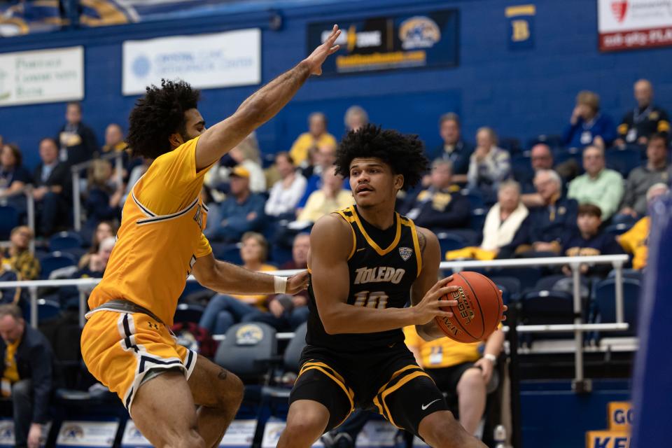 Toledo guard RayJ Dennis looks for an open teammate under the basket while being guarded by Kent State guard Sincere Carry during an NCAA basketball game, Tuesday, Jan. 10, 2023 at the Kent State M.A.C. Center.