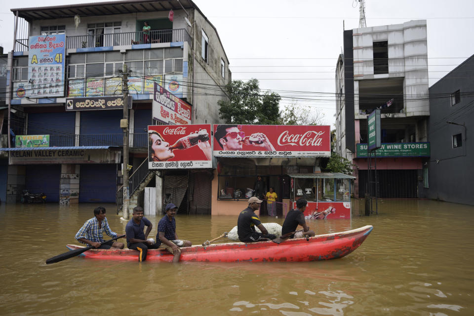 People use a boat to cross a flooded street in Biyagama, a suburb of Colombo, Sri Lanka, Monday, Jun. 3, 2023. Sri Lanka closed schools on Monday as heavy rains triggered floods and mudslides in many parts of the island nation, killing at least 10 people while six others have gone missing, officials said. (AP Photo/Eranga Jayawardena)