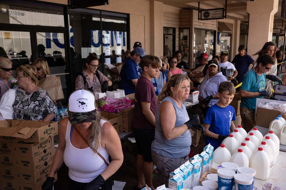 People gather at a distribution center for those affected by the Maui fires at Honokawai Beach Park in Napili-Honokowai, west of Maui, Hawaii, August 14, 2023. The death toll in Hawaii's wildfires rose to 99 and could double over the next 10 days, the state's governor said August 14, as emergency personnel painstakingly scoured the incinerated landscape for more human remains.
Last week's inferno on the island of Maui is already the deadliest US wildfire in a century, with only a quarter of the ruins of the devastated town of Lahaina searched for victims so far. (Photo by Yuki IWAMURA / AFP) (Photo by YUKI IWAMURA/AFP via Getty Images)