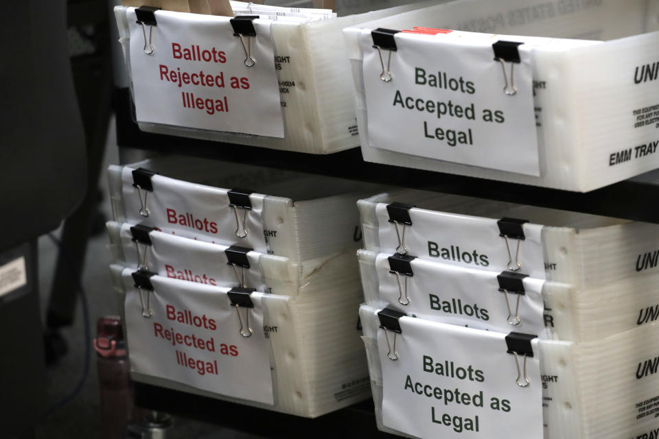 FILE- In this July 30, 2020, file photo, boxes of illegal and legal vote-by-mail ballots are shown at the Miami-Dade County Elections Department in Doral, Fla., as the the Miami-Dade County canvassing board meets to verify signatures on vote-by-mail ballots for the state's Aug. 18 primary election Florida Democrats are building a substantial lead in mail-in ballot requests for November's presidential election, but questions remain about whether that will be a significant advantage for Joe Biden as he tries to wrest the nation's largest swing state from President Donald Trump. (AP Photo/Lynne Sladky, File)