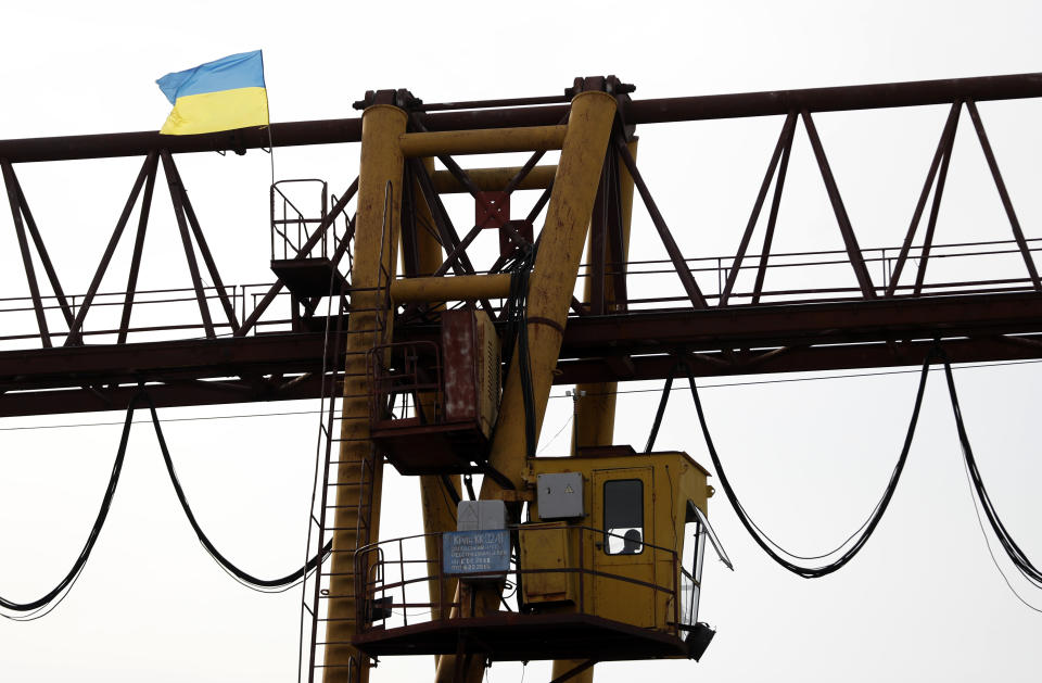 In this Friday, Oct. 19, 2018 photograph, a man operates a loading crane at a logistics center in Chop, Ukraine. A new education law that could practically eliminate the use of Hungarian and other minority languages in schools after the 4th grade is just one of several issues threatening this community of 120,000 people. Many are worried that even as Ukraine strives to bring its laws and practices closer to European Union standards, its policies for minorities seem to be heading in a far more restrictive direction. (AP Photo/Laszlo Balogh)
