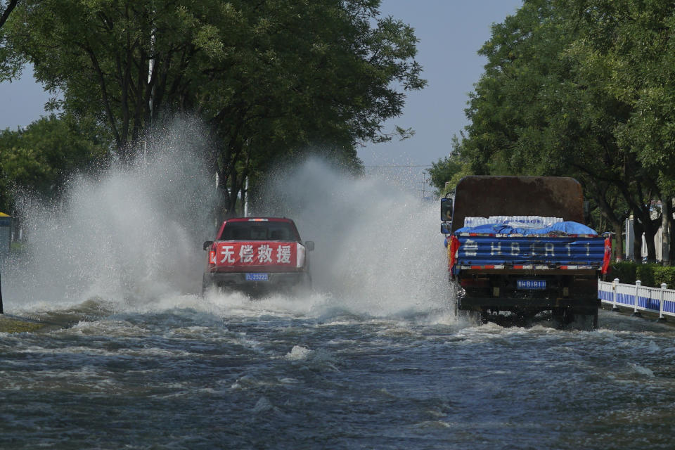 A truck with a banner which reads "Free Assistance" drives through floodwaters in Xinxiang in central China's Henan province on Sunday, July 25, 2021. Trucks carrying water and food on Sunday streamed into the Chinese city at the center of flooding that killed dozens of people, while soldiers laid sandbags to fill gaps in river dikes that left neighborhoods under water. (AP Photo/Dake Kang)