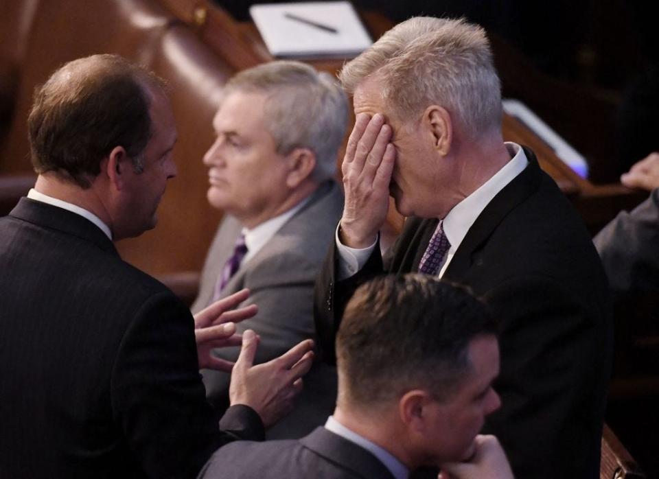 Kevin McCarthy puts his face in his hands on the House floor