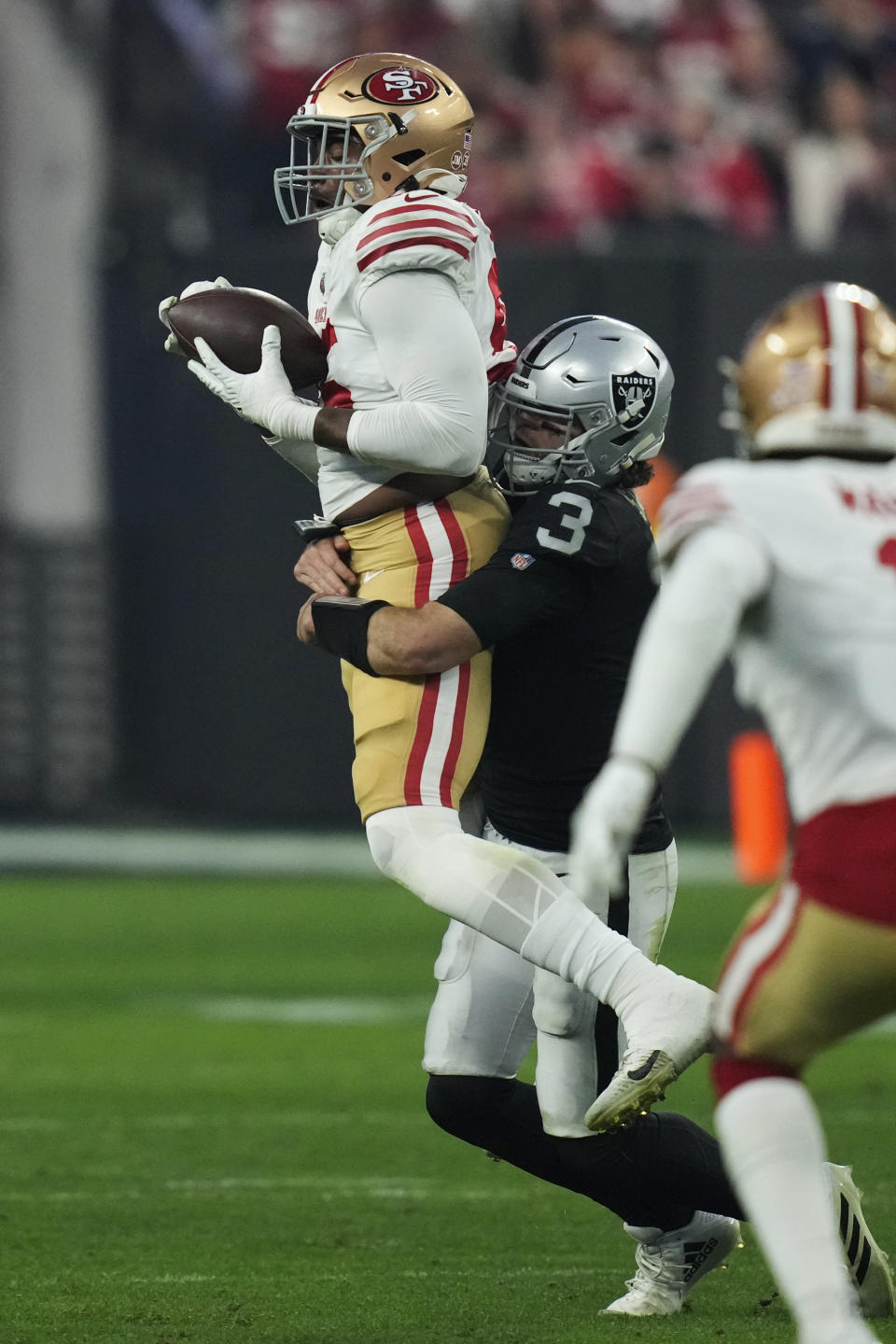 San Francisco 49ers defensive end Drake Jackson (95) is tackled by Las Vegas Raiders quarterback Jarrett Stidham after catching an interception during the second half of an NFL football game between the San Francisco 49ers and Las Vegas Raiders, Sunday, Jan. 1, 2023, in Las Vegas. (AP Photo/John Locher)