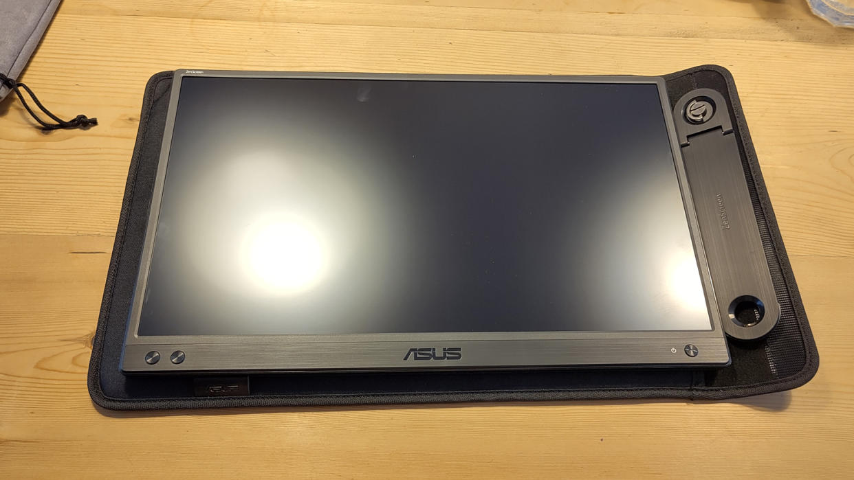  An ASUS ZenScreen MB166CR portable monitor sitting on a desk. 