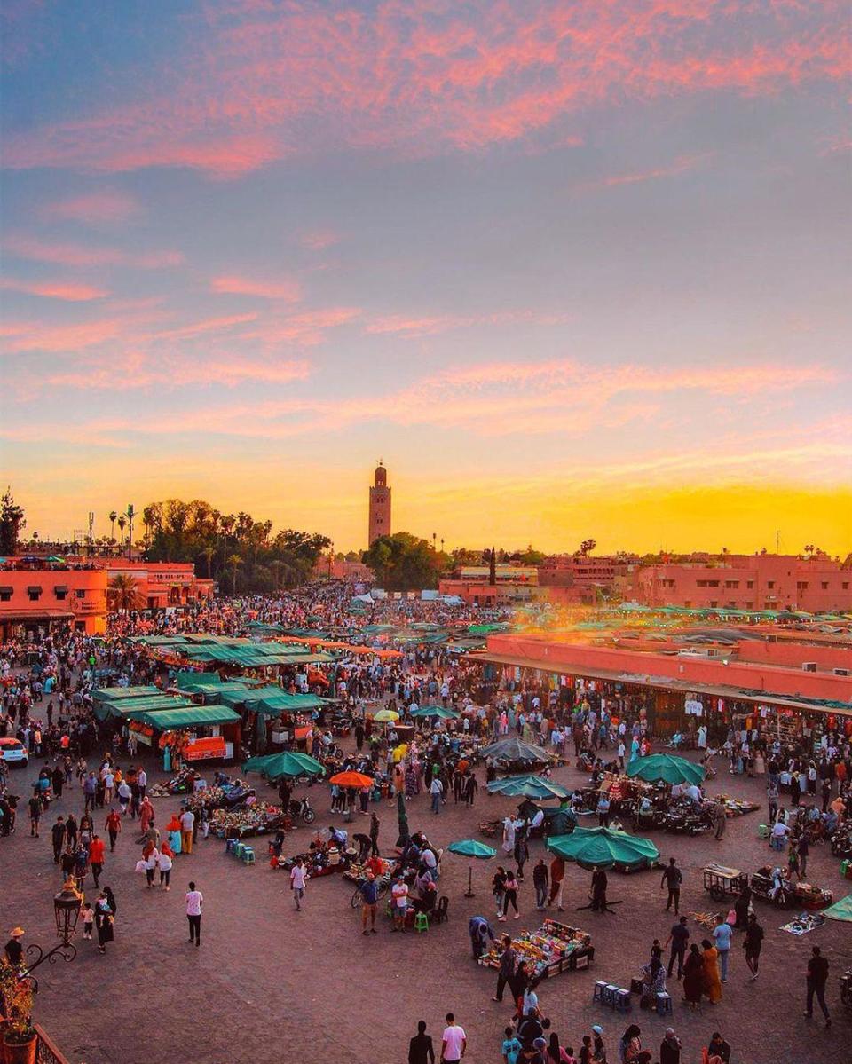 La majestuosa Mezquita Kutubía en el fondo de la vibrante plaza Jemaa el-Fna.