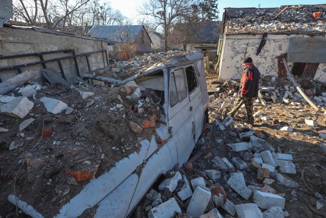 A local resident walks next to his destroyed car at a site of a residential area hit by a Russian missile strike, amid Russia's attack of Ukraine, in Kharkiv, Ukraine March 31, 2023 (REUTERS)