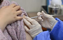 A nursing home worker, left, receives the first dose of the AstraZeneca COVID-19 vaccine at a health care center in Seoul Friday, Feb. 26, 2021. South Korea on Friday administered its first available shots of coronavirus vaccines to people at long-term care facilities, launching a mass immunization campaign that health authorities hope will restore some level of normalcy by the end of the year. (Jung Yeon-je /Pool Photo via AP)