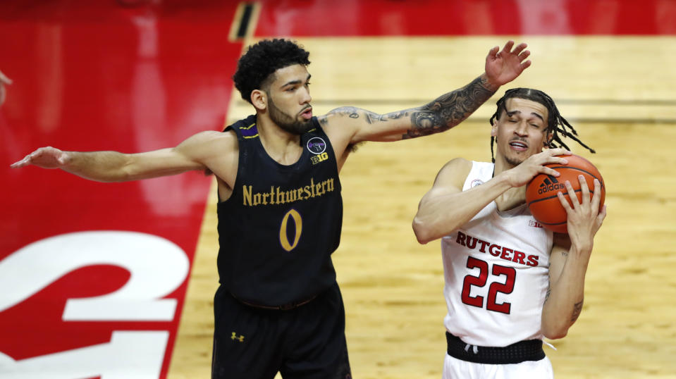 Northwestern's Boo Buie (0) defends against Rutgers' Caleb McConnell (22) during the first half of an NCAA college basketball game in Piscataway, N.J., Saturday, Feb. 13, 2021. (AP Photo/Noah K. Murray)