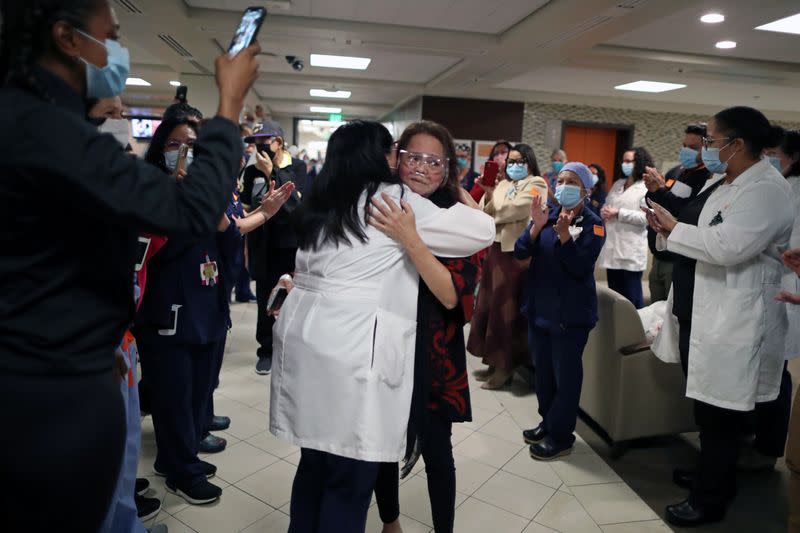 Intensive Care Unit Nurse Merlin Pambuan, is hugged by hospital staff as she walks out of the hospital in Long Beach