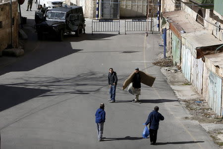 Jewish settlers carry their belongings after they were forcibly removed by Israeli troops from homes, in the West Bank city of Hebron, January 22, 2016. REUTERS/Mussa Qawasma