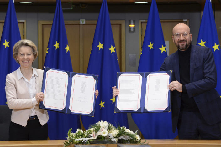 FILE - In this Wednesday, Dec. 30, 2020 file photo, European Commission President Ursula von der Leyen, left, and European Council President Charles Michel show the signed EU-UK Trade and Cooperation Agreement at the European Council headquarters in Brussels. A last-minute trade deal with the United Kingdom coupled with the rollout of COVID-19 vaccines in the final days of the year produced a sense of success for the 27-nation bloc and brought glimmers of hope to the EU's 450 million residents. (Johanna Geron/Pool Photo via AP, File)