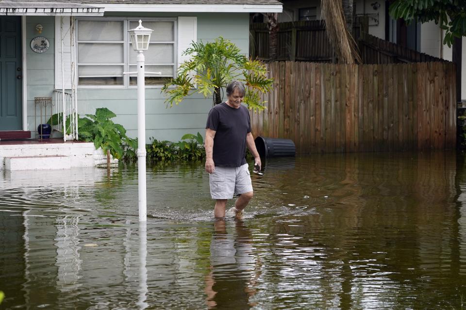 FILE - Don Hawthorne walks across his flooded yard in unincorporated Pinellas County, Fla., after the storm surge from Hurricane Idalia moved by the area, Aug. 30, 2023. The National Oceanic and Atmospheric Administration announced Monday, Sept. 11, that there have been 23 weather extreme events in America that cost at least $1 billion this year through August, eclipsing the year-long record total of 22 set in 2020. (AP Photo/Chris O'Meara, File)