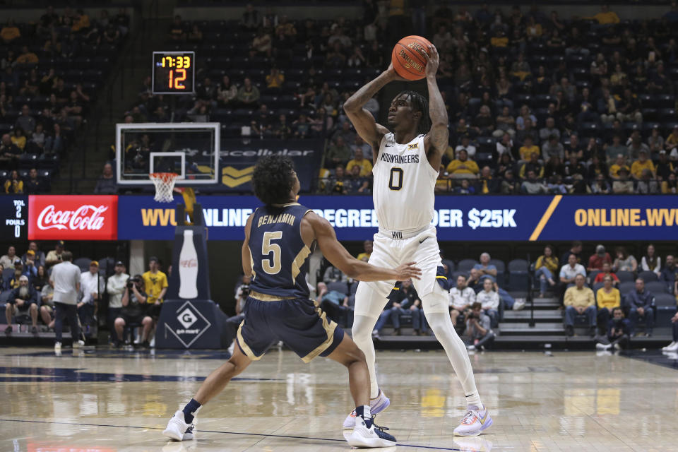 West Virginia guard Kedrian Johnson (0) is defended by Mount St. Mary's guard Jalen Benjamin (5) during the second half of an NCAA college basketball game in Morgantown, W.Va., Monday, Nov. 7, 2022. (AP Photo/Kathleen Batten)
