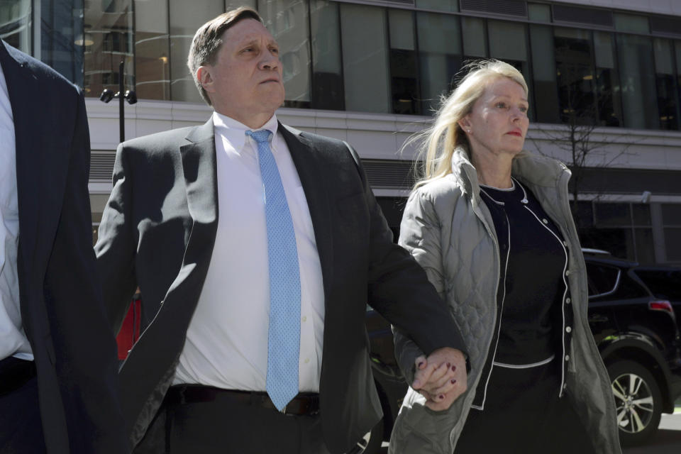 FILE - John Wilson arrives at federal court, with his wife Leslie, on April 3, 2019 to face charges in a nationwide college admissions bribery scandal in Boston. John Wilson and Gamal Abdelaziz convicted of buying their kids’ way into elite universities will stay out of prison while they appeal their cases in the college admissions bribery scheme, a Boston judge ordered Thursday, May 19, 2022. (AP Photo/Charles Krupa, File)