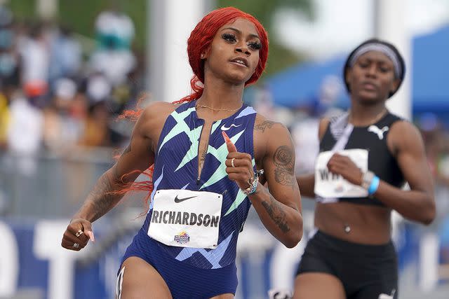 <p>Kirby Lee via AP</p> Sha'Carri Richardson sporting her iconic orange hair while competing.