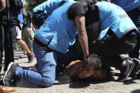 Police detain a soccer fan at Plaza de Mayo, where mourners are lining up to see the casket with the remains of Diego Maradona lying in state inside the presidential palace, in Buenos Aires, Argentina, Thursday, Nov. 26, 2020. The Argentine soccer great who was among the best players ever and who led his country to the 1986 World Cup title died from a heart attack at his home Wednesday, at the age of 60. (AP Photo/Rodrigo Abd)