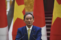 Japan's Prime Minister Yoshihide Suga speaks during a press briefing with his Vietnamese counterpart Nguyen Xuan Phuc, following an exchange documents ceremony at the Government Office in Hanoi Monday, Oct. 19, 2020. Prime Minister Suga, in his first summit foray since taking office last month, agreed with his Vietnamese counterpart to step up defense and security cooperation in the face of China's expanding influence in the region. (Nhac Nguyen/Pool Photo via AP)