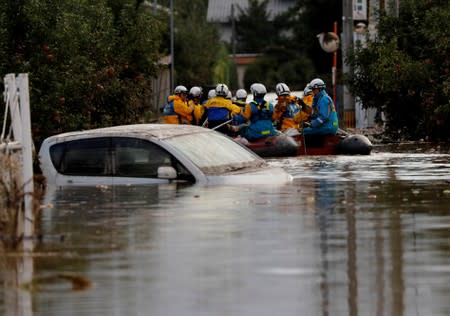 Rescue workers search a flooded area in the aftermath of Typhoon Hagibis, which caused severe floods at the Chikuma River in Nagano