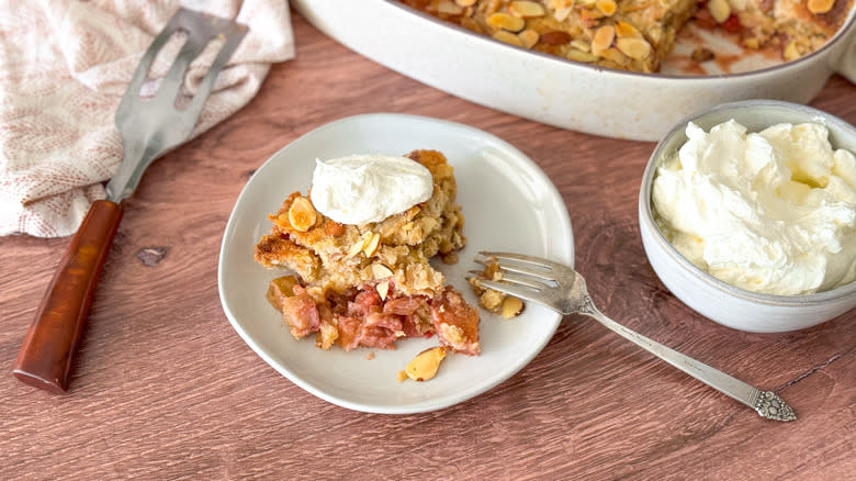 Almond-rhubarb from scratch dump cake with almond whipped cream on table