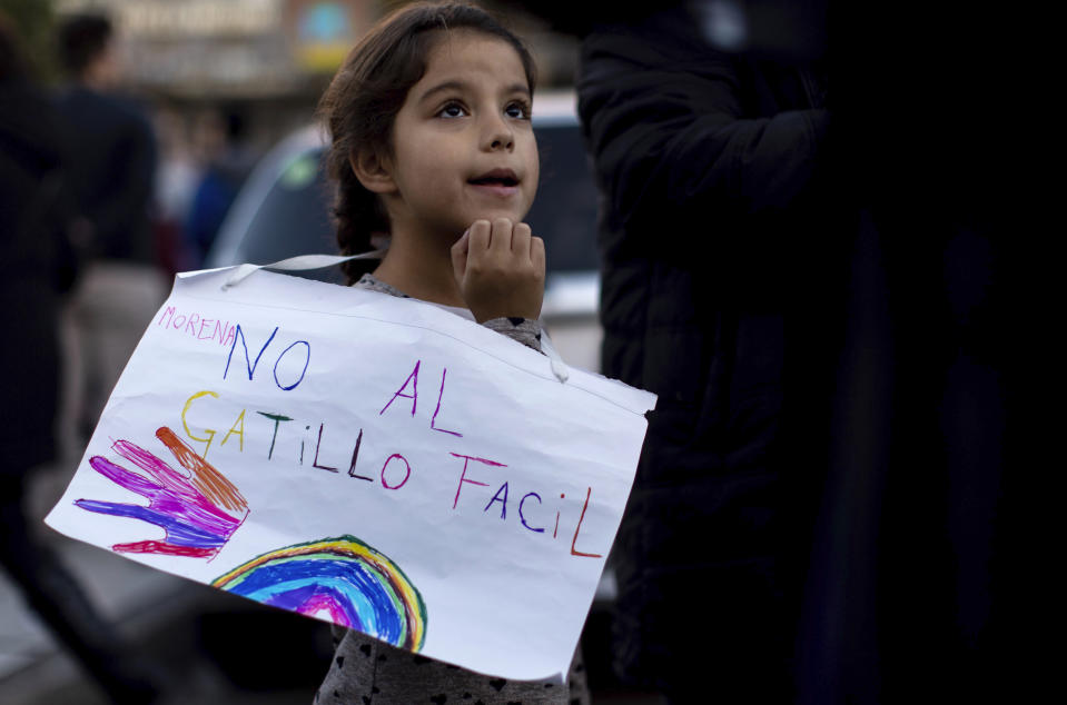 A girl holds a sign that reads in Spanish "No to the easy trigger" during a march against police brutality, in Buenos Aires, Argentina, Friday, May. 24, 2019. Argentines protested after officers on Monday fired shots that led to the deaths of three teenagers and a young man in a car chase. (AP Photo/Tomas F. Cuesta)