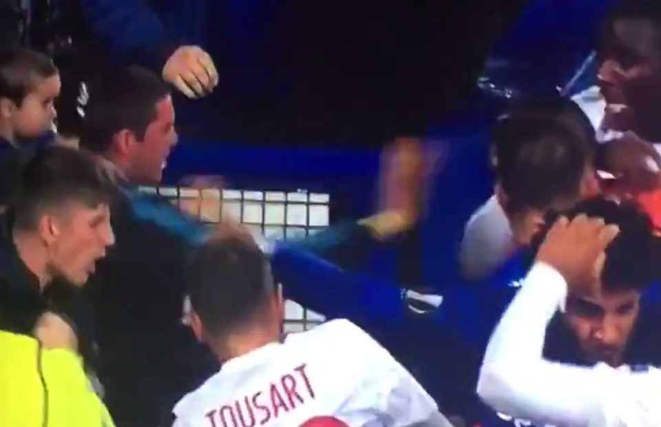 An Everton fan holding a child makes contact with a Lyon player. (Screenshot: Twitter)