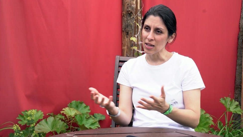 Nazanin Zaghari-Ratcliffe speaking at a table surrounded by plants