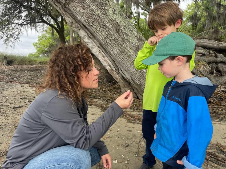 Christy Richard teaches two students about the Fiddler crabs that live in South Carolina.