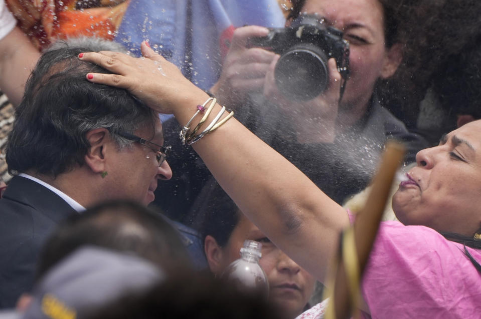 An Indigenous woman spits water onto the head of President-elect Gustavo Petro, during a 'popular and spiritual' inauguration ceremony presided over by local Indigenous groups and feminist activists, in Bogota, Colombia, Saturday, Aug. 6, 2022. Petro, the first left-wing Colombian president in 200 years, will be sworn in as the country’s new president on Sunday, Aug. 7. (AP Photo/Ariana Cubillos)