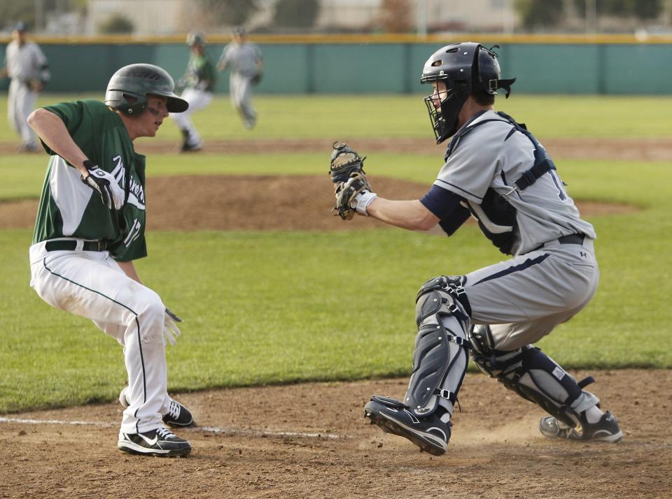 El Diamante's Patrick Jones, left, is tagged out at home in a West Yosemite League game versus Redwood in 2012.