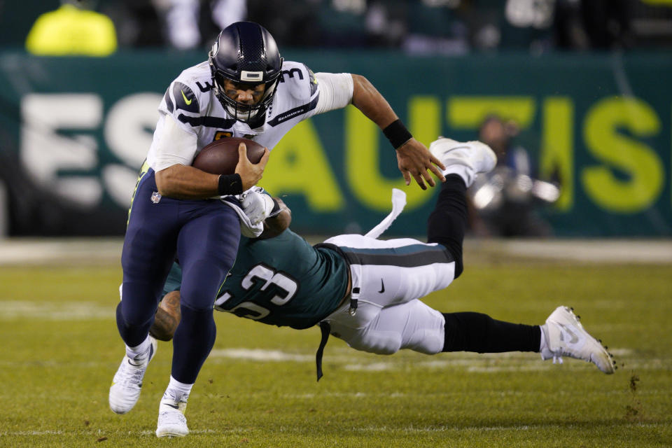 Seattle Seahawks' Russell Wilson (3) rushes past Philadelphia Eagles' Nigel Bradham (53) during the second half of an NFL wild-card playoff football game, Sunday, Jan. 5, 2020, in Philadelphia. (AP Photo/Chris Szagola)