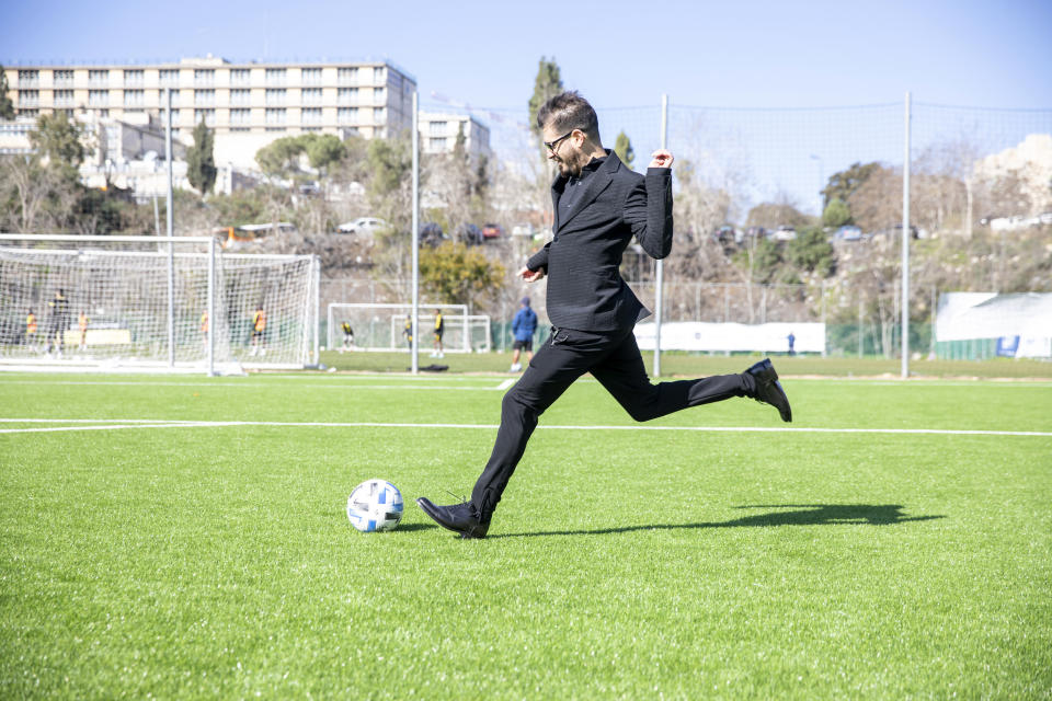 Moshe Hogeg, one of the owners of Beitar Jerusalem FC soccer club, plays with a ball, in the team training ground in Jerusalem, Sunday, Dec. 27, 2020. The owner of Israel's Beitar Jerusalem soccer club has given himself an ambitious task. Weeks after bringing in a wealthy Emirati investor as co-owner, Hogeg says he is determined to remove the stain of racism from his team. Beitar is the only major Israeli team never to have signed an Arab player, and its fans have been known to make racist chants at matches. Hogeg says he and his Emirati partner aim to turn the team into both an Israeli soccer powerhouse and a model of coexistence. "We are actively looking for A-class players," he says. "Religion is not a factor by any means." (AP Photo/Ariel Schalit)