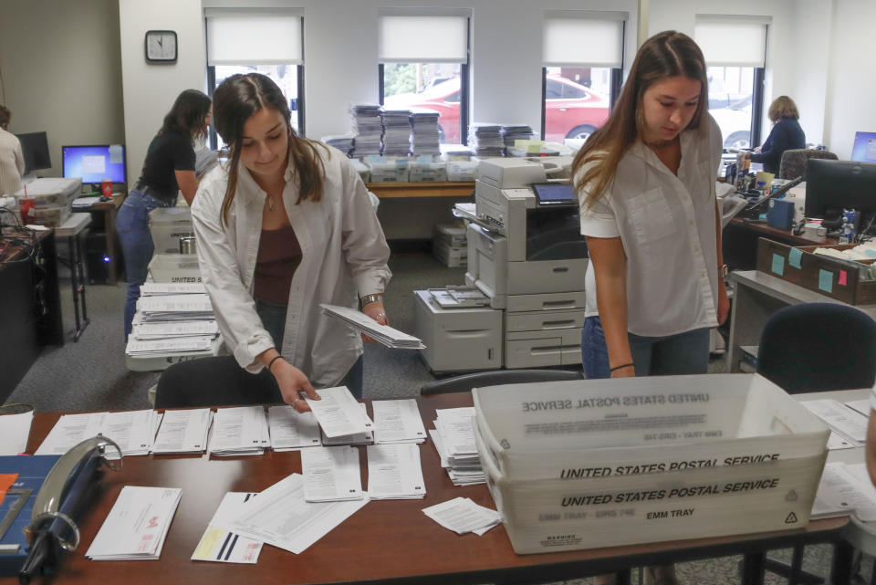 FILE - Processors work on mail in ballots for the Pennsylvania Primary election is being done by Emily Pellegrino, left, and Danielle Beardsley at the Butler County Bureau of Elections, May 28, 2020, in Butler, Pa. State laws in the crucial battleground states of Pennsylvania, Michigan and Wisconsin force most mail-in ballots to be processed and counted after Election Day, sometimes stretching the process by a week or more. That lag time in getting results opens the door to lies and misinformation that can sow distrust about the eventual outcome in close races.(AP Photo/Keith Srakocic, File)