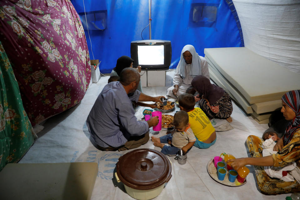 A displaced Iraqi family from Mosul eat a simple meal for their Iftar, during the Muslim holy month of Ramadan at a refugee camp al-Khazir in the outskirts of Erbil, Iraq June 10, 2017. Picture taken June 10, 2017.   REUTERS/Erik De Castro