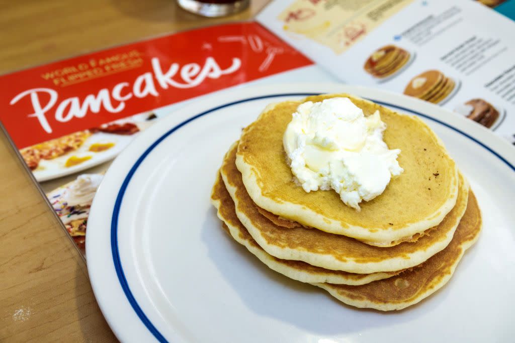 stack of pancakes on a plate on a table with ihop menu below it