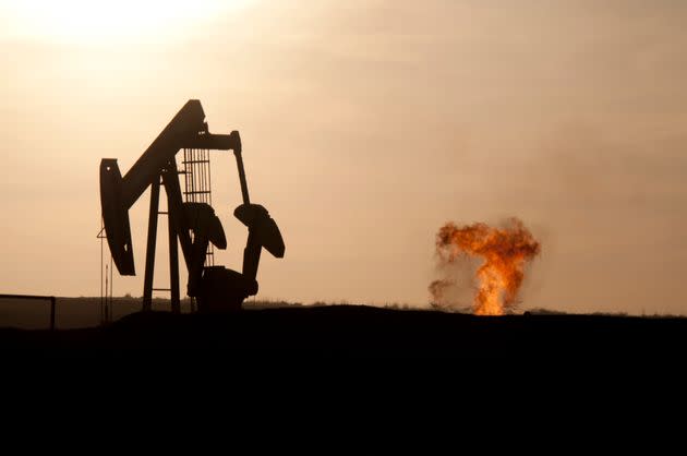 An oil well jack pump and a natural gas flare-off at sunset in the Bakken oil field north of Williston, North Dakota. (Photo: Photo by William Campbell/Corbis via Getty Images)