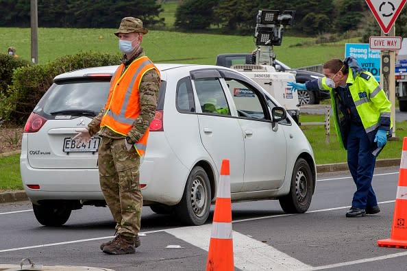 Police and military personnel check vehicles leaving the city at a COVID-19 check point setup at the southern boundary in Auckland.