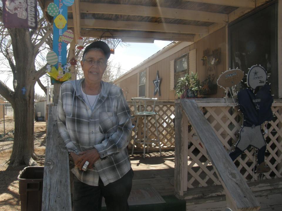 Olivia Aguilar, a resident of Deming, speaks with a reporter from her porch.
