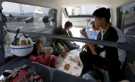 A family of evacuee who have been using their vehicle for shelter rest after a series of earthquakes in Mashiki town, Kumamoto prefecture, southern Japan, in this photo taken by Kyodo April 19, 2016. Mandatory credit Kyodo/via