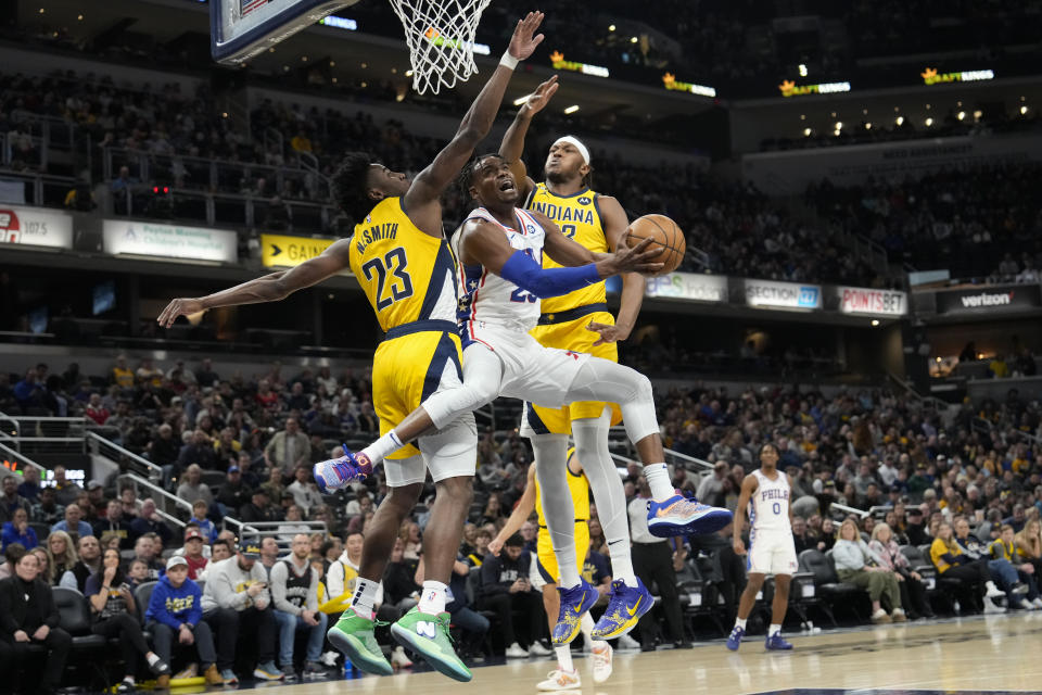 Philadelphia 76ers forward Danuel House Jr., center, shoots between Indiana Pacers defenders Aaron Nesmith, left, and Myles Turner during the first half of an NBA basketball game in Indianapolis, Saturday, March 18, 2023. (AP Photo/AJ Mast)