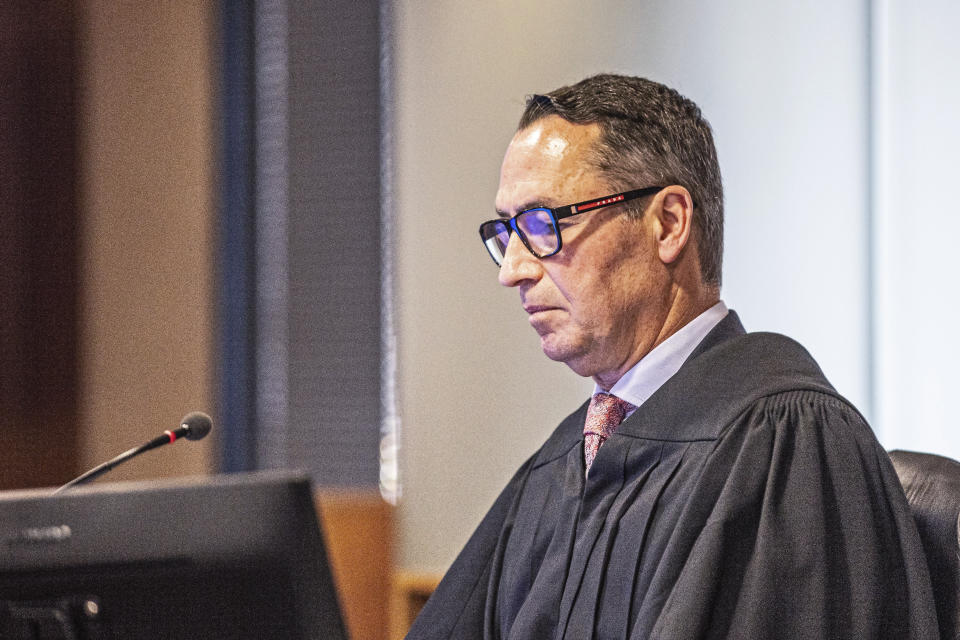 Judge Evangelos Thomas listens to evidence in Auckland, New Zealand, on Tuesday, July 11, 2023, on the first day of a trial after a volcano eruption at a popular tourist island destination killed 22 people in December 2019. The island's owners, brothers Andrew, James and Peter Buttle, their company Whakaari Management Ltd. and tour operators I.D. Tours NZ Ltd. and Tauranga Tourism Services Ltd. went on trial in Auckland District Court for allegedly failing to adequately protect tourists and staff. (Lawrence Smith/Pool Photo via AP)