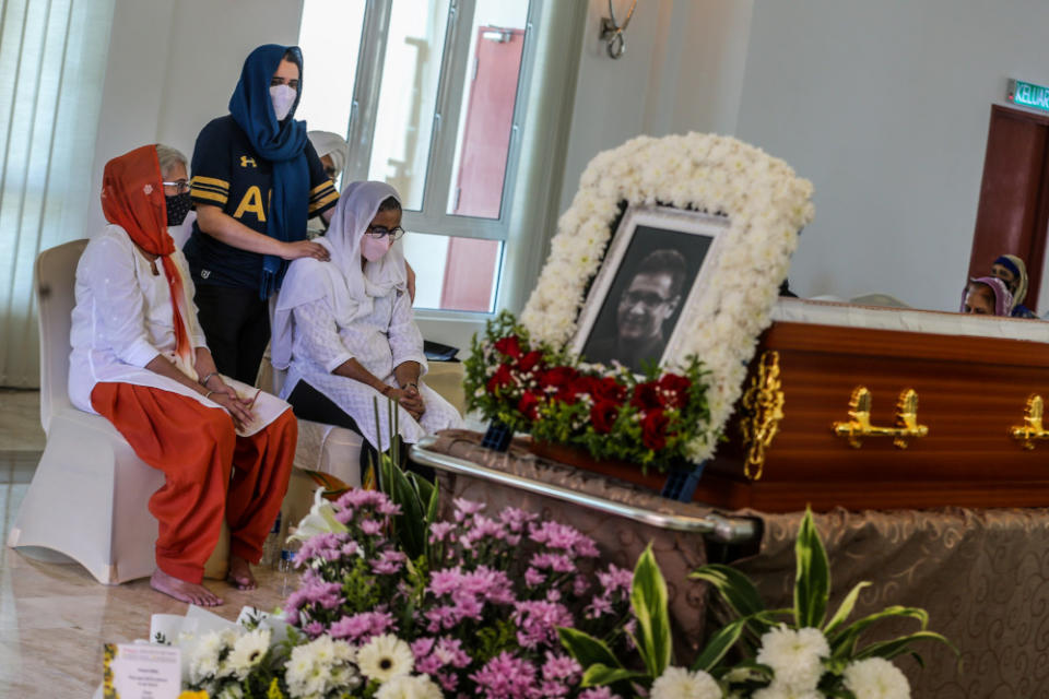 Shebby Singh’s wife Harbans Kaur (right) consoled by relatives as she sits by Shebby’s casket during the wake at Shamshan Bhoomi Hall, Kuala Lumpur January 14, 2022. — Picture by Hari Anggara