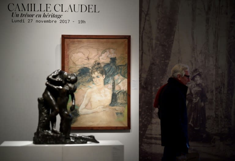 The star item in the sale of Claudel's works is L'Abandon, seen here alongside a picture of the artist as a visitor admires her oeuvres at the Artcurial auction house in Paris