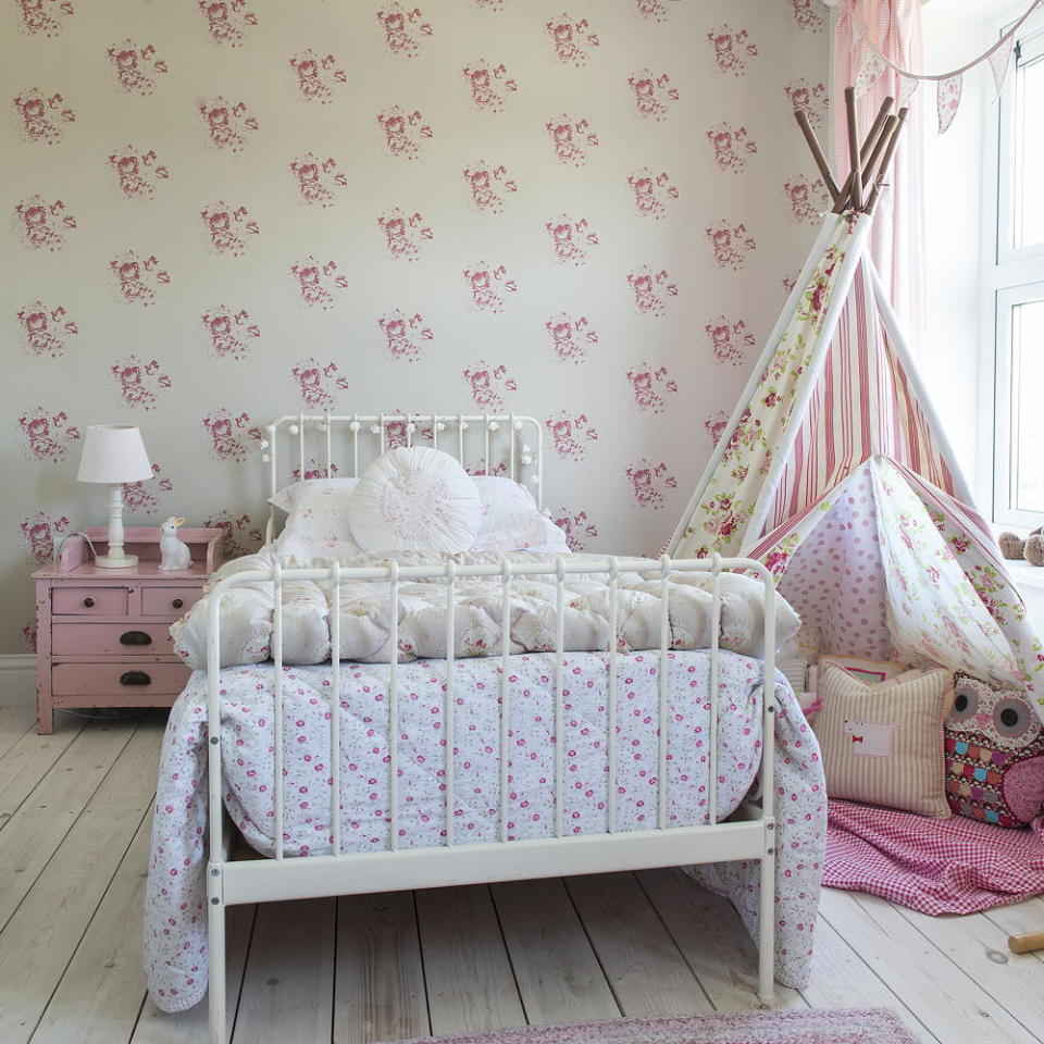 kids room with wooden flooring, wrought iron bed and floral wallpaper