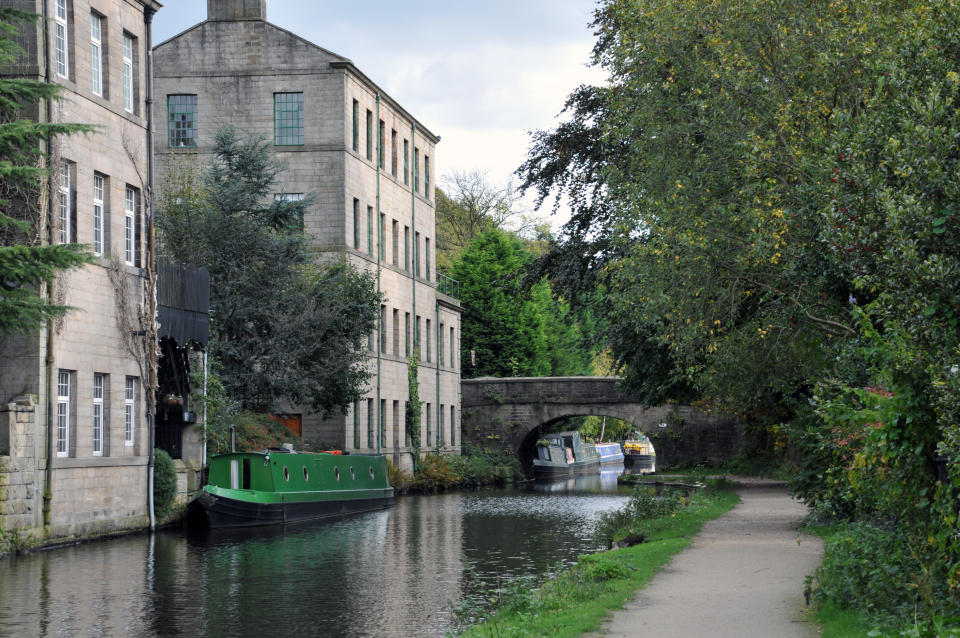 hebden bridge with the rochdale canal with a bridge, towpath boats and old buildings